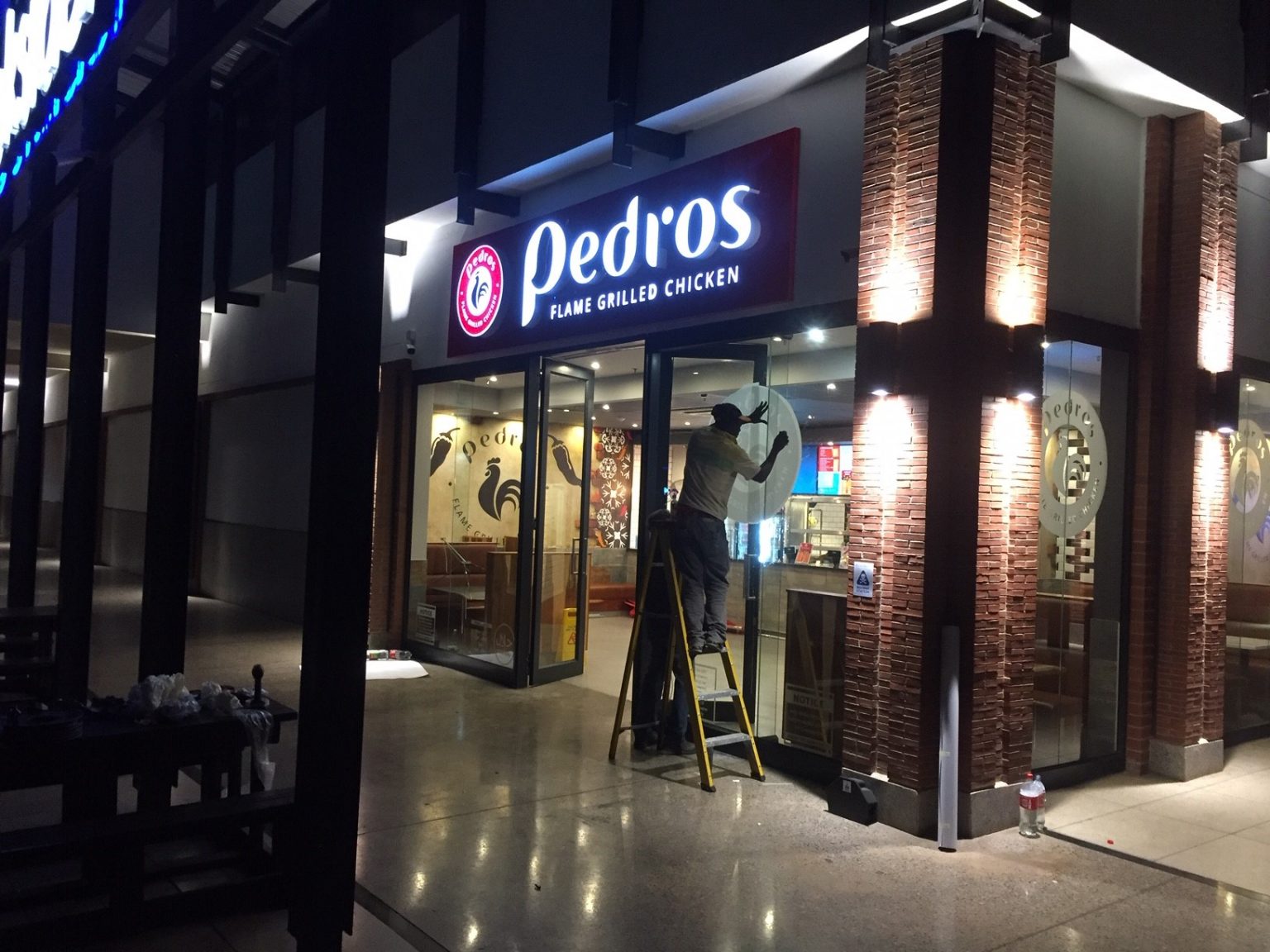 Team installing LED signage on storefront